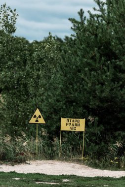 Pripyat, Ukrayna - 15 Ağustos 2019: yeşil ağaçların yanında sarı uyarı işaretleri ile çernobil bölgesi 