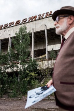 Pripyat, Ukrayna - 15 Ağustos 2019: üst düzey bir adam fotoğraf tutan harflerle bina seçici odak 