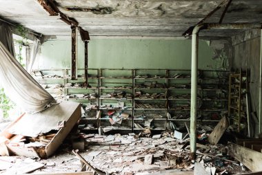 Pripyat, Ukrayna - 15 Ağustos 2019: okulda yerde kitaplar ile kirli ve terk edilmiş kütüphane 