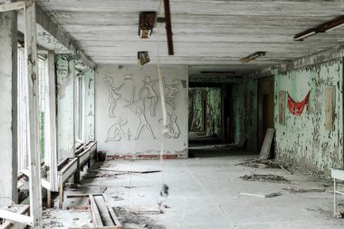 PRIPYAT, UKRAINE - AUGUST 15, 2019: abandoned and creepy classroom with dirty walls in school  clipart