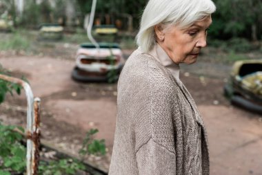Pripyat, Ukrayna - 15 Ağustos 2019: lunaparkta duran üzgün yaşlı kadın 