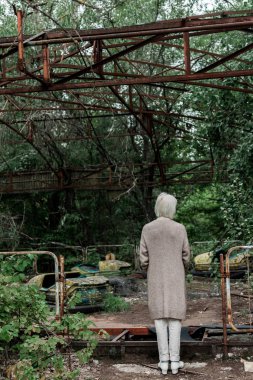 Pripyat, Ukrayna - 15 Ağustos 2019: lunaparkta duran yaşlı kadının arka görünümü 