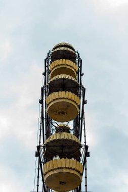 PRIPYAT, UKRAINE - AUGUST 15, 2019: low angle view of yellow ferris wheel against blue sky with clouds  clipart