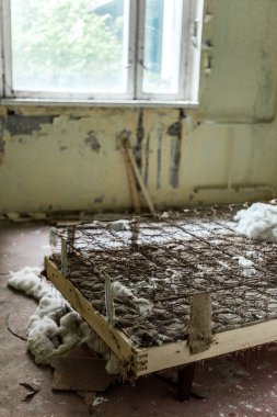 selective focus of rusty bed in damaged bedroom in chernobyl  clipart