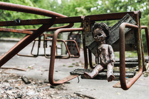 burnt baby doll on abandoned carousel in chernobyl 