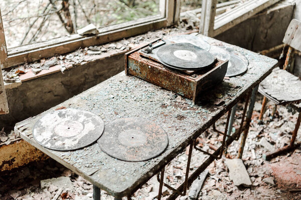 abandoned vinyl records on dirty table in room 