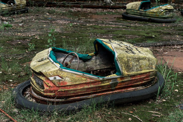 PRIPYAT, UKRAINE - AUGUST 15, 2019: abandoned and damaged bumper cars in amusement park 