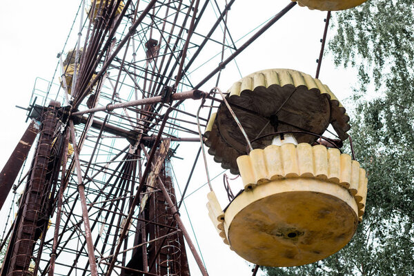 PRIPYAT, UKRAINE - AUGUST 15, 2019: low angle view of metallic ferris wheel in amusement park against sky