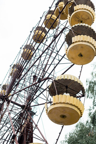 PRIPYAT, UKRAINE - AUGUST 15, 2019: low angle view of ferris wheel in amusement park against sky in chernobyl 