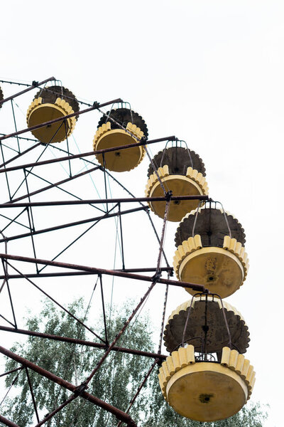 PRIPYAT, UKRAINE - AUGUST 15, 2019: low angle view of ferris wheel in amusement park against sky with copy space