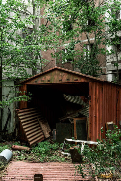 металлический гараж рядом с зелеными деревьями и здания
 