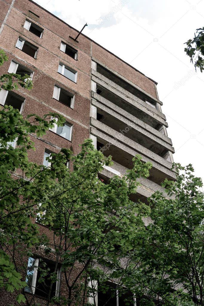 low angle view of brown building near green trees in chernobyl 