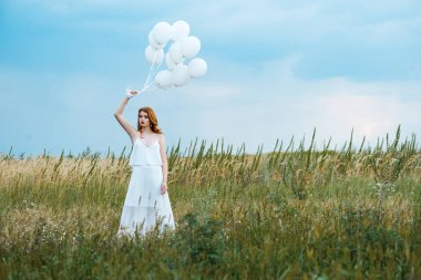 çimenli alanda balonları tutan kızıl saçlı kız seçici odak 