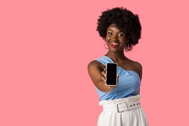 pembe izole boş ekran ile akıllı telefon tutan neşeli afrikalı amerikalı kız 