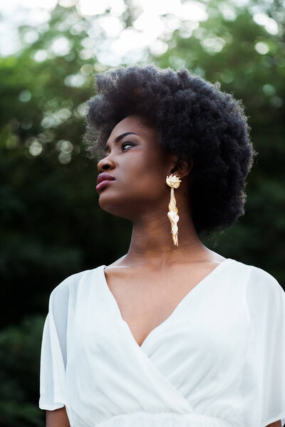 low angle view of beautiful and curly african american girl 