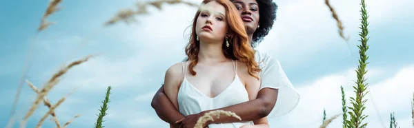 Plano Panorámico Joven Afroamericana Mujer Abrazando Pelirroja Contra Cielo Azul — Foto de Stock