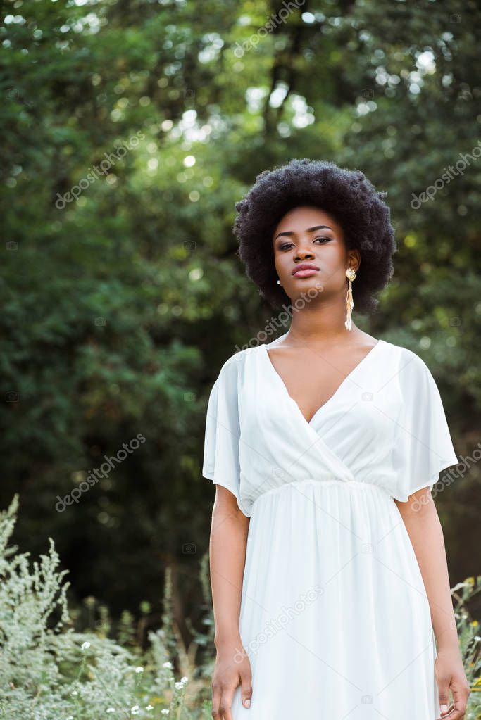 selective focus of attractive and curly african american girl looking at camera