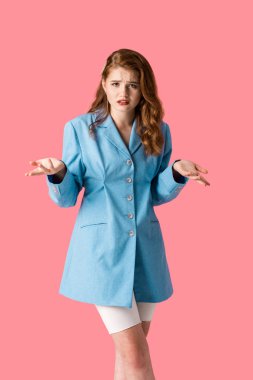 pembe izole omuz silkme jesti gösterirken kamera bakarak üzgün kız 