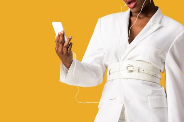 turuncu izole akıllı telefon tutan sürpriz afrikalı amerikalı kız kırpılmış görünümü