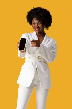 turuncu izole parmak ile işaret ederken boş ekran ile akıllı telefon tutan mutlu afrikalı amerikalı kız 