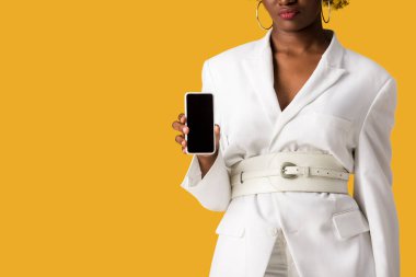turuncu izole boş ekran ile akıllı telefon tutan africna Amerikan kadın kırpılmış görünümü 
