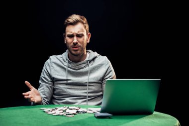 dizüstü bilgisayar ve poker yongaları siyah izole yakın gesturing üzgün adam 
