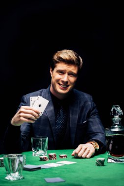 Kyiv, Ukrayna - 20 Ağustos 2019: elinde kağıt tutan ve siyah üzerinde poker oynayan mutlu adamın seçici odak noktası 
