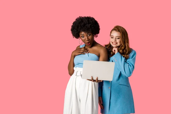 Meglepett Afro Amerikai Nézi Laptop Boldog Vöröshajú Lány Izolált Rózsaszín — Stock Fotó