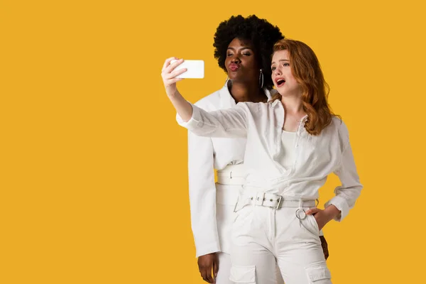 Meninas Multiculturais Atraentes Tomar Selfie Isolado Laranja — Fotografia de Stock