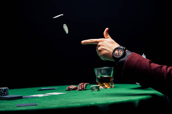 обрезанный вид человек бросая в воздух фишки покер изолированы на черный
 