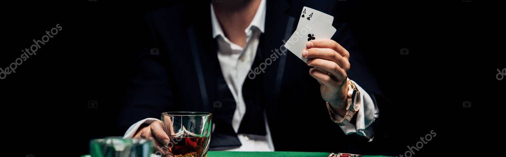 KYIV, UKRAINE - AUGUST 20, 2019: panoramic shot of man holding playing cards isolated on black