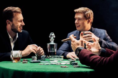 siyah poker kulübünde arkadaşlarının yanında puro tutan adam kırpılmış görünümü 