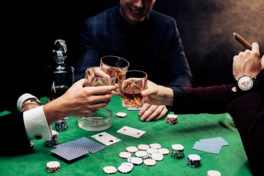 Kyiv, Ukrayna - 20 Ağustos 2019: Poker masasının yanında siyah dumanlı kadeh kaldıran erkeklerin görüntüsü 