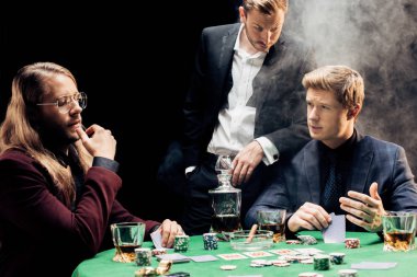 Kyiv, Ukrayna - 20 Ağustos 2019: Siyah üzerine dumanla poker oynayan yakışıklı adamlar 