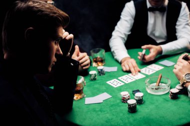 Kyiv, Ukrayna - 20 Ağustos 2019: Poker masasına yakın bir adamın seçici odak noktası 