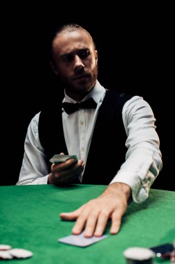 Kyiv, Ukrayna - 20 Ağustos 2019: Krupiyenin seçici odak noktası poker masasının üzerine izole edilmiş oyun kartı koymak 