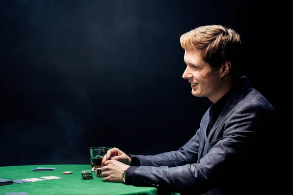 Siyah Üzerine Dumanla Poker Oynayan Mutlu Adamın Yan Görünüşü — Stok fotoğraf