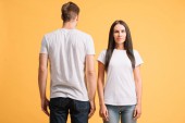 beautiful couple posing in white t-shirts, isolated on yellow