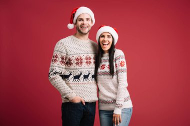 güzel heyecanlı çift santa şapka ve kazak kırmızı izole poz