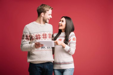 kırmızı izole dijital tablet kullanarak kış kazak mutlu çift