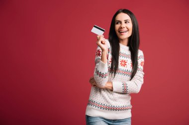 kırmızı izole kredi kartı tutan kış kazak mutlu kadın 