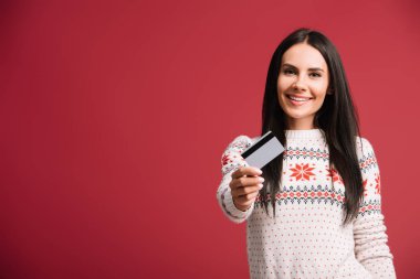 kırmızı izole kredi kartı tutan kış kazak neşeli kadın 