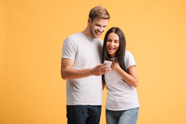 sarı izole akıllı telefon kullanarak güzel çift