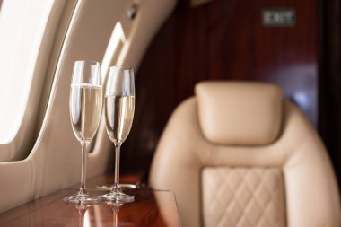 Yolculuk için şampanya kadehleriyle uçağın iç kısmının seçici odağı