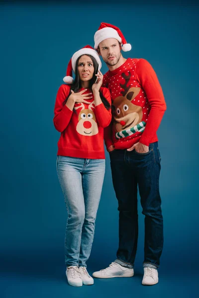 Escandalizado Mujer Santa Hat Hablando Smartphone Mientras Hombre Escuchar Aislado —  Fotos de Stock