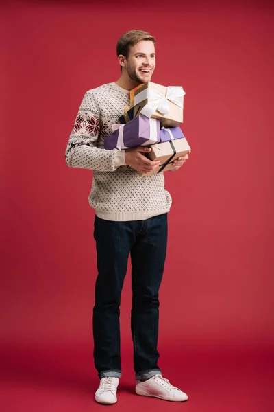 Cheerful Young Man Holding Christmas Presents Isolated Red — Stock Photo, Image