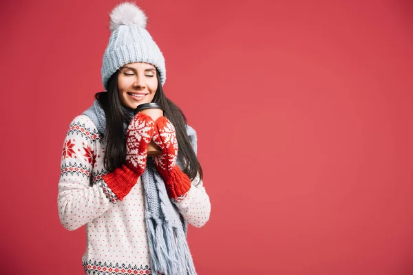幸福的女人在冬天的帽子 围巾和手套拿着咖啡去 隔离在红色 — 图库照片