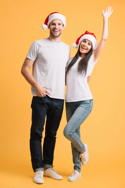 Coppia Eccitata Cappelli Babbo Natale Divertirsi Sul Giallo — Foto Stock