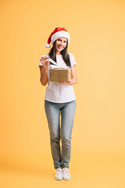 Beautiful Smiling Girl Santa Hat Holding Christmas Present Isolated Yellow — Stock Photo, Image