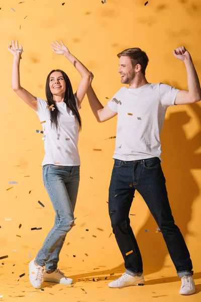 Belo Casal Feliz Dançando Amarelo Com Confete Dourado — Fotografia de Stock